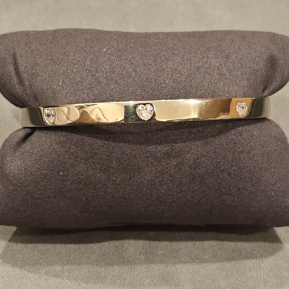 Heart shape Cubic Zirconia bangle set in sterling silver. Push lock closure.